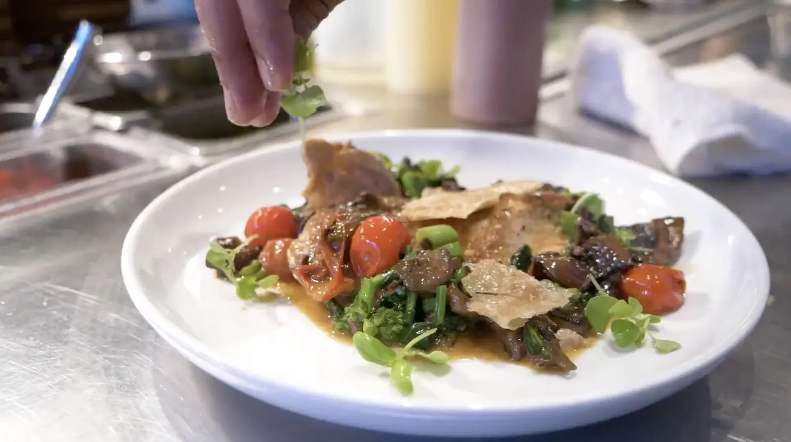 A chef finishing a plated dish