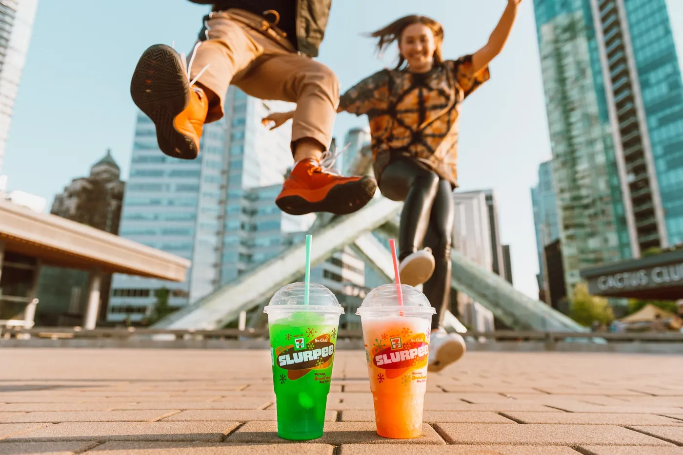 Two dancers jumping with Slurpees in downtown Toronto