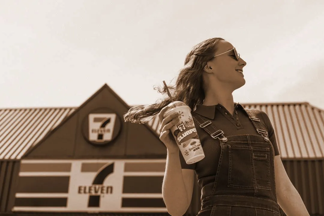 A dancer in front of a 7-Eleven store